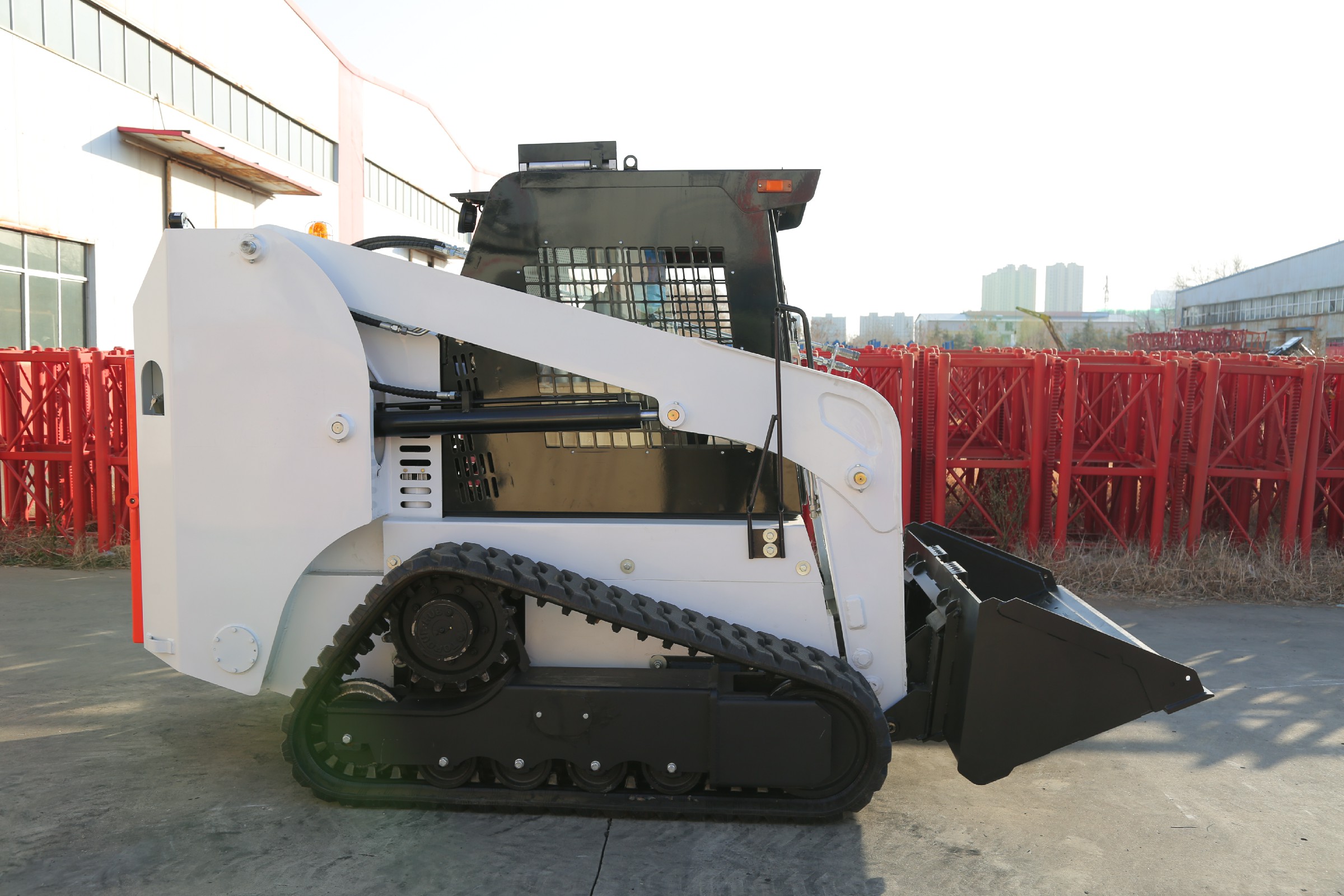 Huayee HJC100 track skid steer, side view with bucket lowered