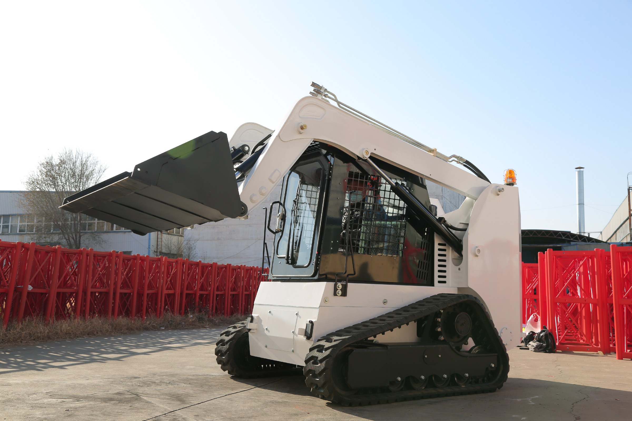 Huayee HJC100 track skid steer, front-quarter view with bucket raised