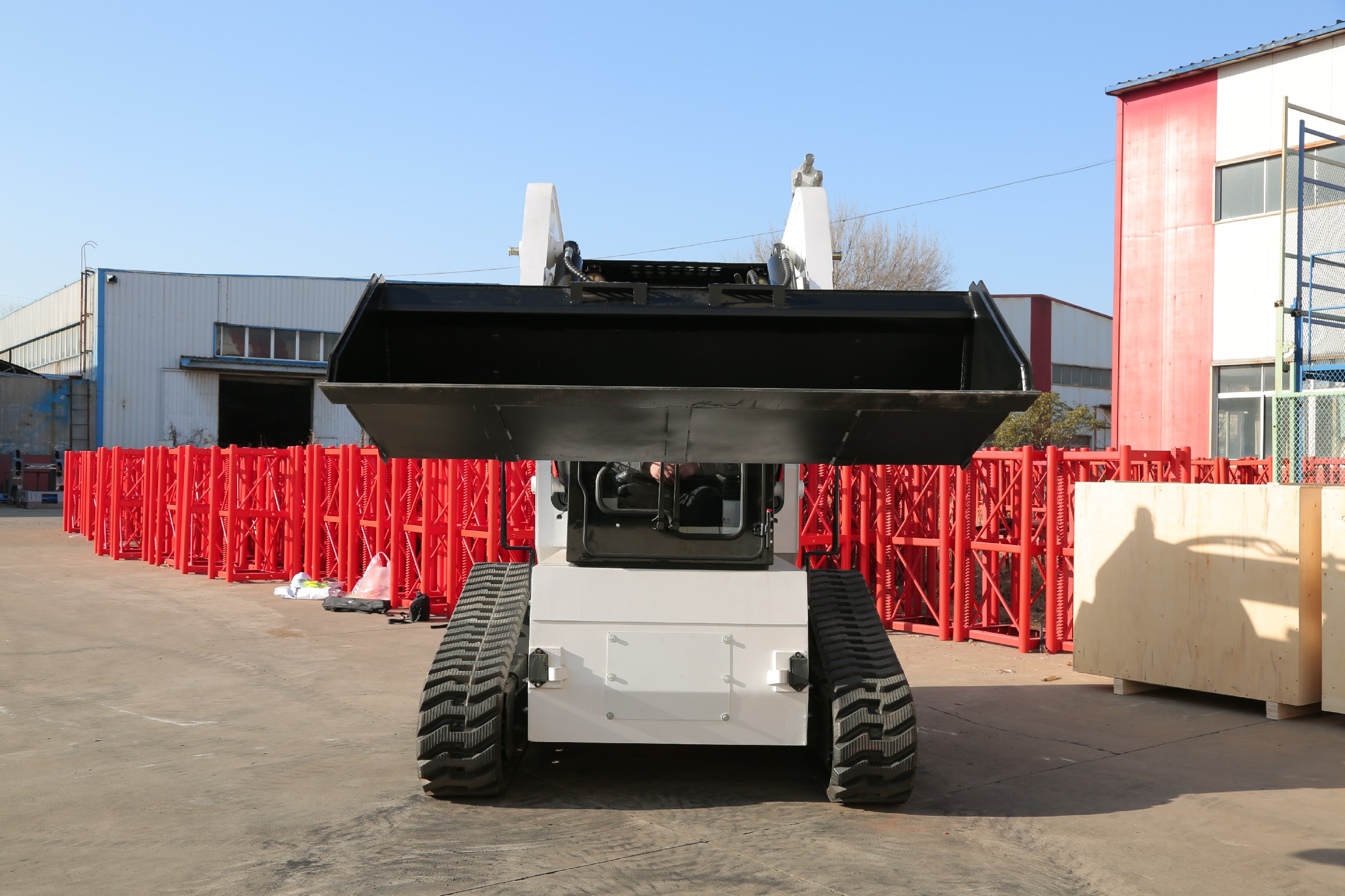 Huayee HJC100 track skid steer, rear view with bucket raised
