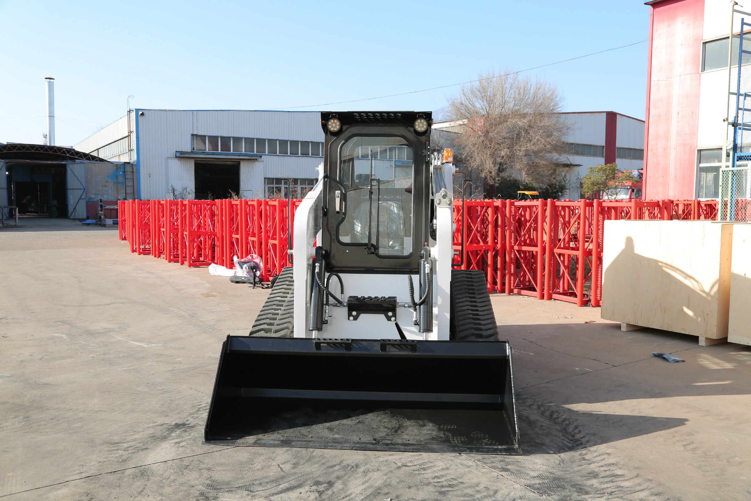 Huayee HJC100 track skid steer, front view with bucket lowered