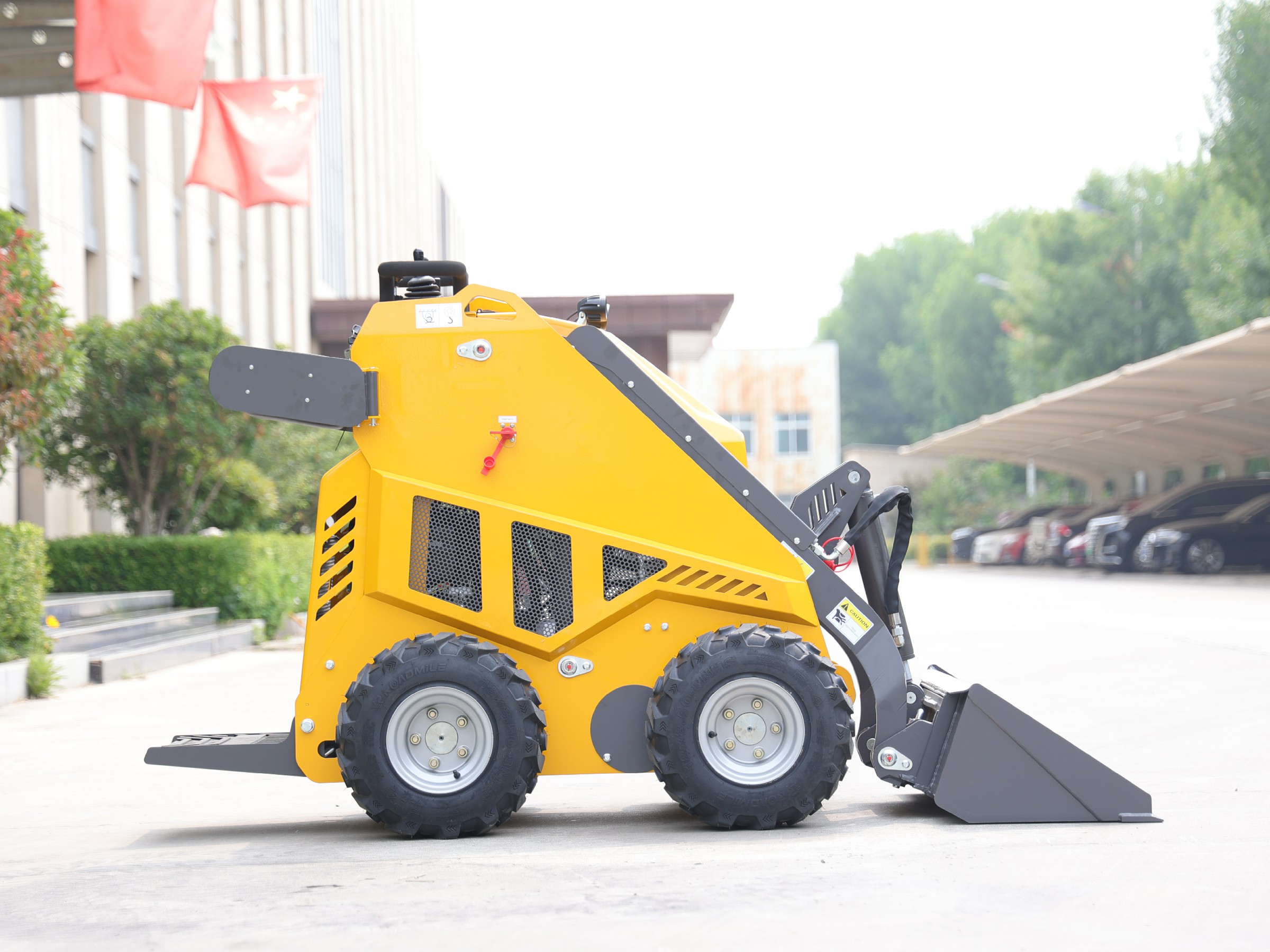 Huayee HY360W mini skid steer, side view with bucket lowered and forks mounted on rear